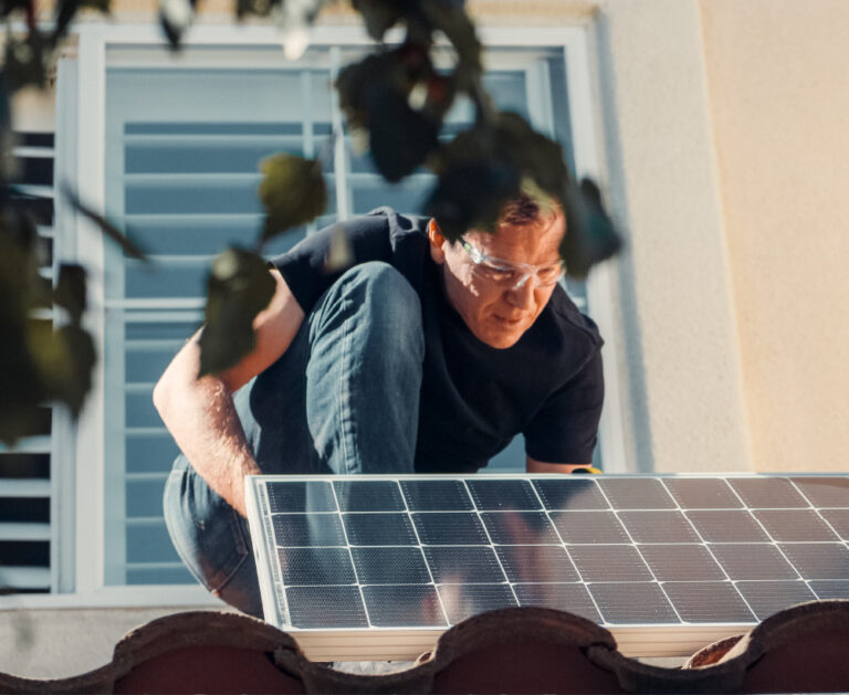 HTechniker montiert Photovoltaikmodul auf einem Hausdach